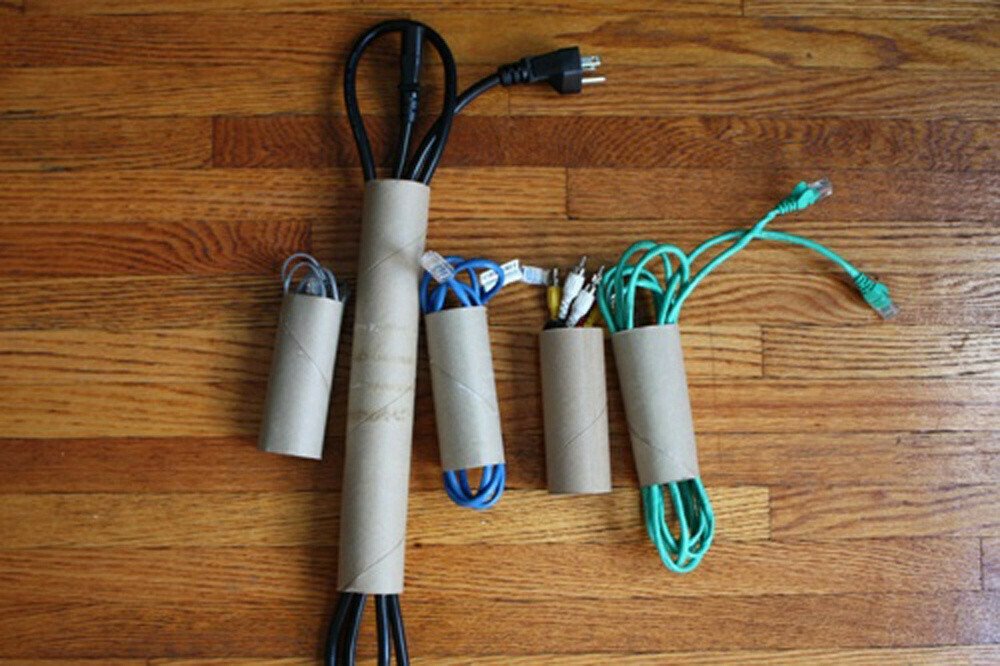 Cordones y cables enrollados en paquetes y asegurados dentro de un rollo de papel toalla, y otros cuatro en rollos de papel higiénico más pequeños