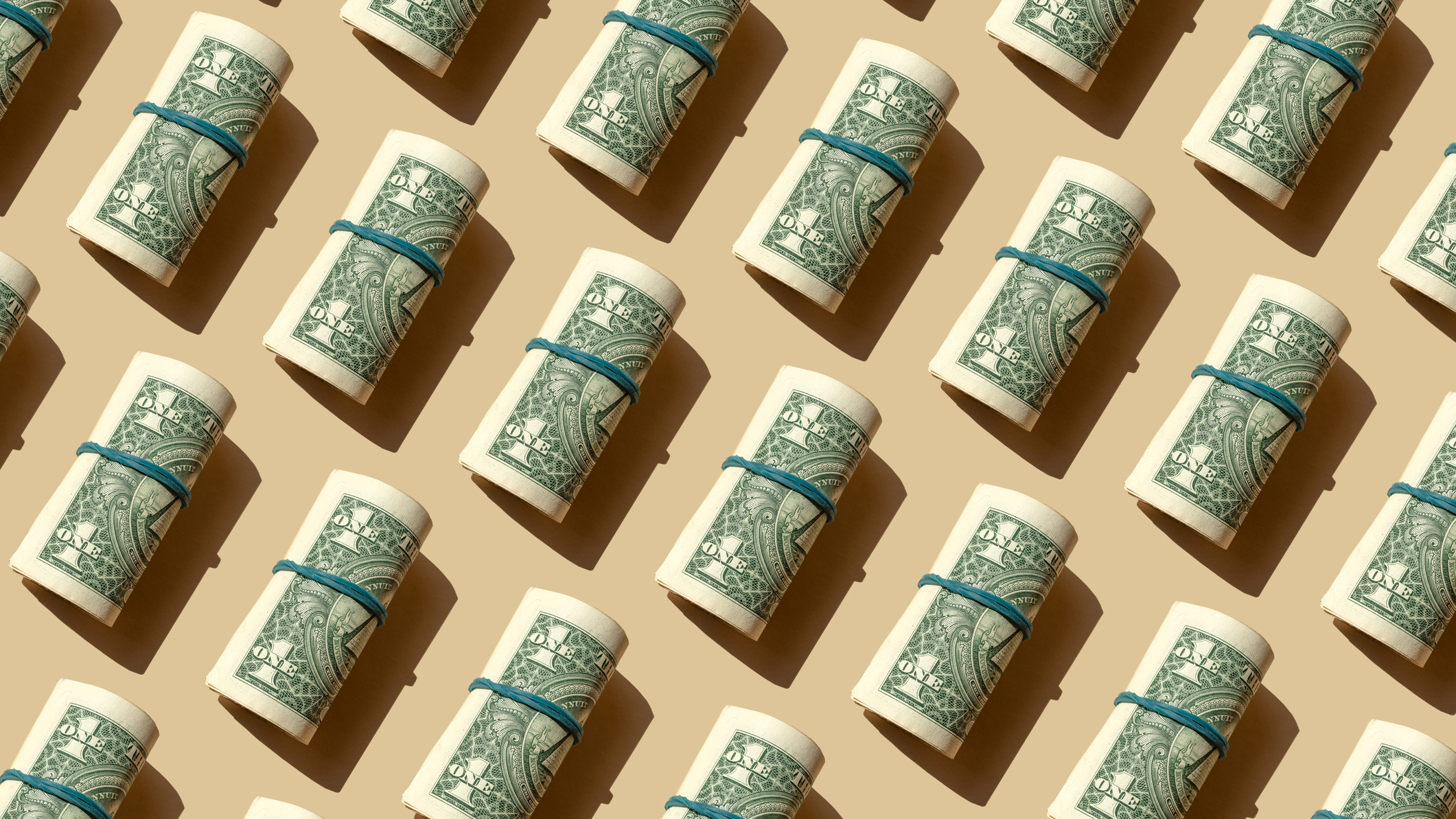 Rollo de billetes de dólares americanos en el fondo beige - Fotografía de stock