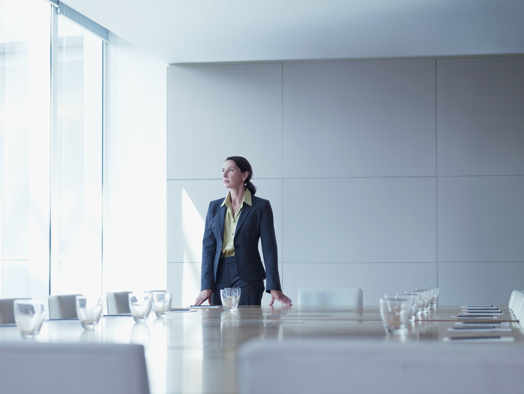 Businesswoman standing alone in conference room - Fotografía de stock