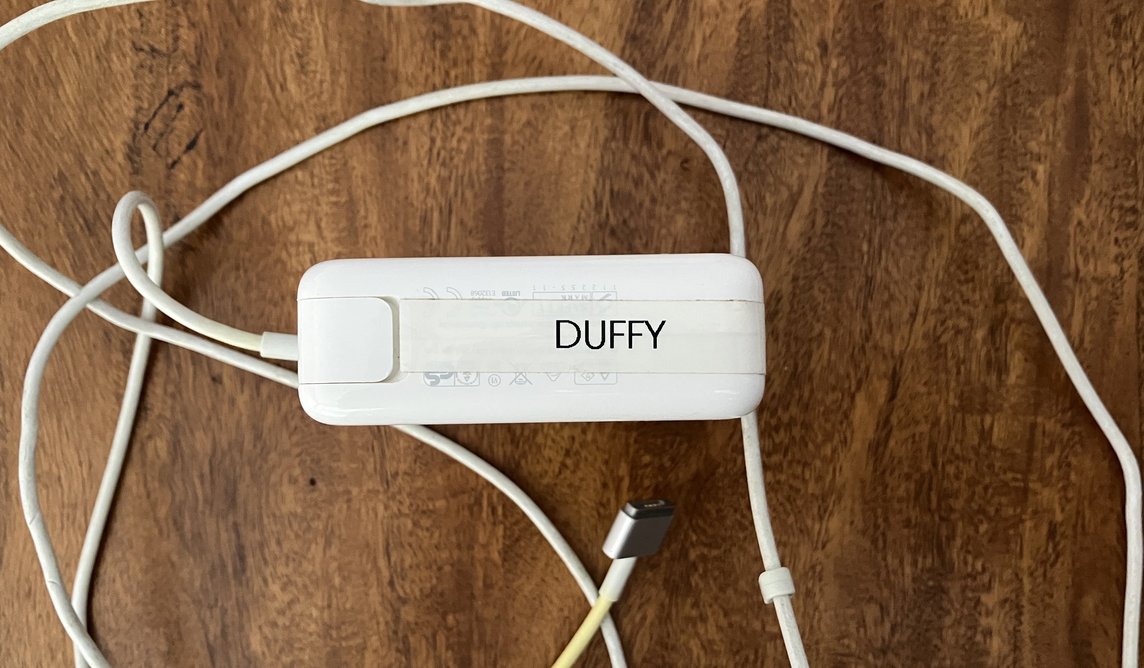 Un cargador de Mac etiquetado con el nombre Duffy